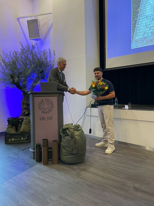 Chairman Hennie de Hoog thanking Kamil Aerts for presentation of his book